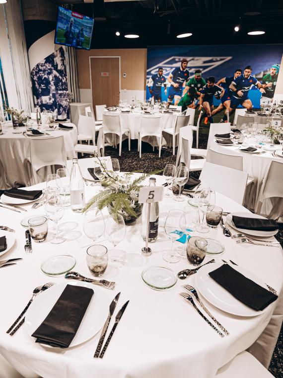 L'espace hospitalité Village Officiel du Stade de France vue sur une table et un écran de retransmission du match