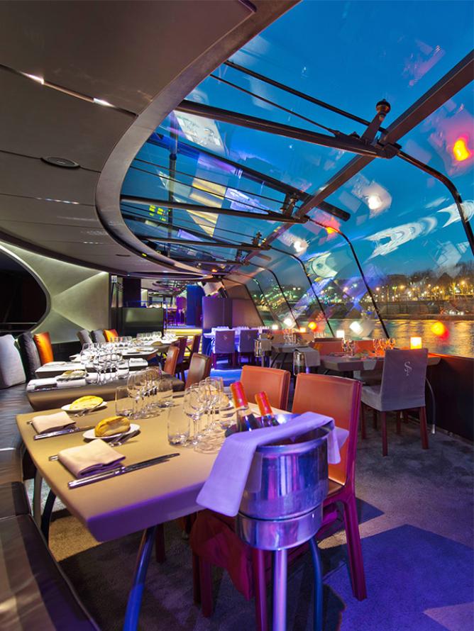 Table served for a delicious dinner during a cruise on the Seine on a fly boat Bateaux Parisiens