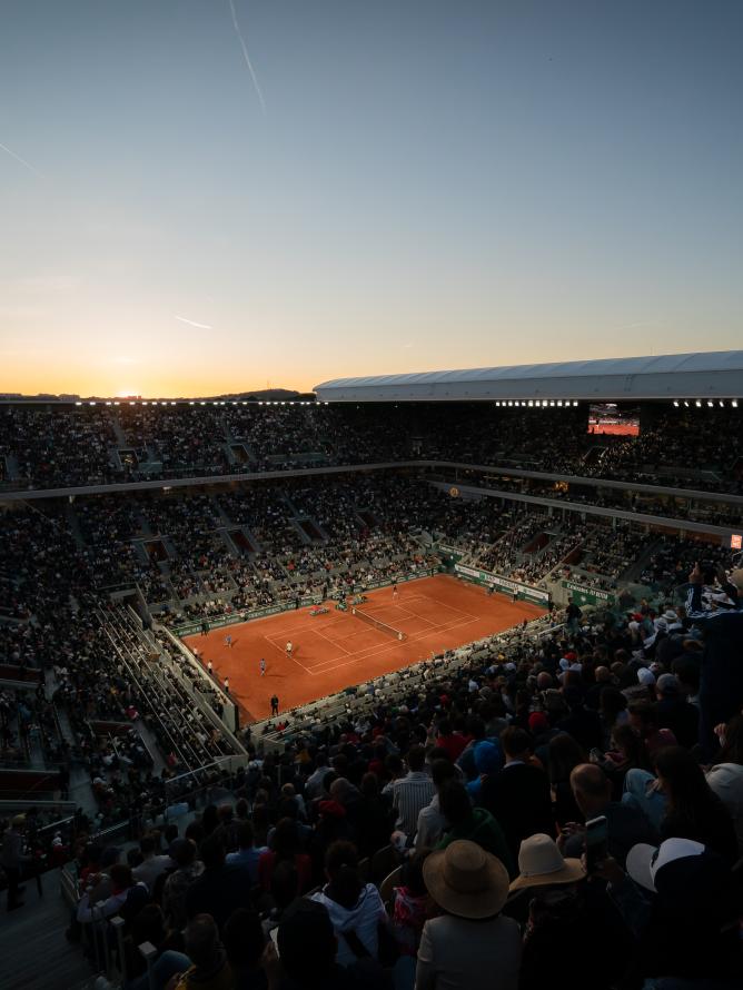 Une vue sur le Court Philippe-Chatrier de Roland Garros depuis les gradins pendant un match en soirée