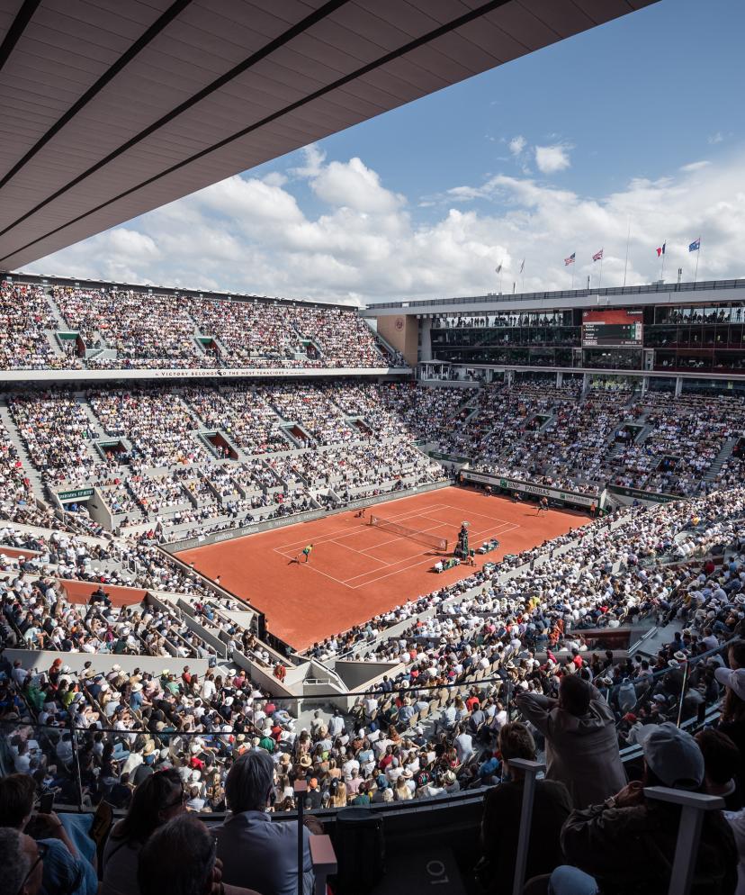 Public cheering during a Roland Garros match on a clay court